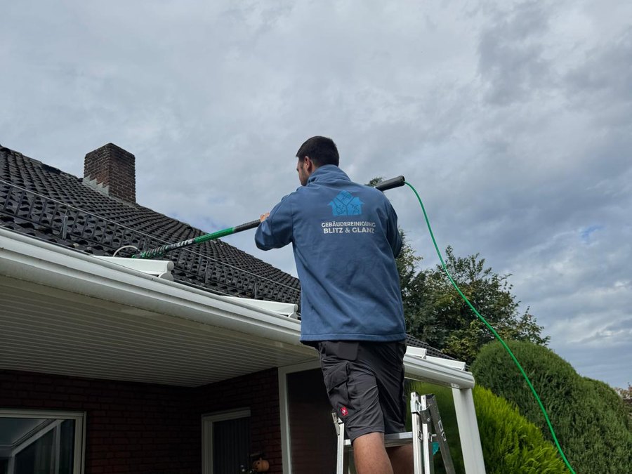 Mitarbeiter von Blitz und Glanz reinigt mit wasserführender Teleskopstange die Dachrinne eines Einfamilienhauses in Oelde